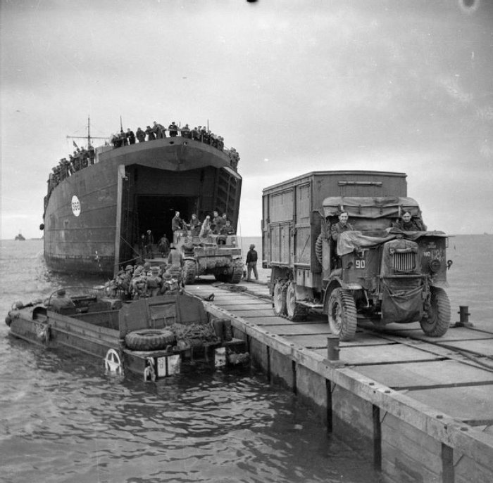 An Albion lorry and Sexton 25pdr self-propelled gun come ashore at Anzio.jpg